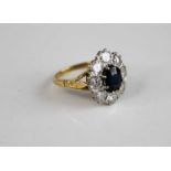 A yellow and white metal, sapphire and diamond oval cluster ring, featuring a centre oval sapphire