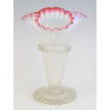 A cranberry and vaseline glass vase, 19th century, of trumpet form, havng a frilled and crimped rim,
