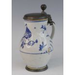 A Delft jug, 18th century, having a pewter lid and footrim, polychrome decorated with a bird amongst