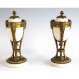 A pair of 19th century neo-Classical white marble and gilt bronze urns and covers, the finial topped