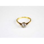 A yellow and white metal diamond solitaire ring, having a round brilliant cut diamond in an eight-