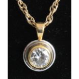 A yellow and white metal diamond single stone pendant, comprising a round brilliant cut diamond in a