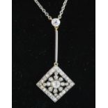 An early Edwardian white metal pendant, comprising an off-set square diamond cluster grain set