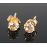 A pair of yellow metal early 20th century single stone diamond earrings, each comprising an old