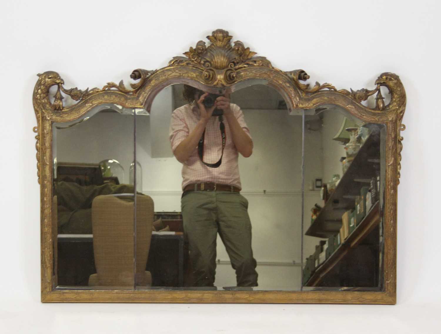 A 19th century giltwood and gesso overmantel mirror, having a triple shaped and bevelled mirrorplate