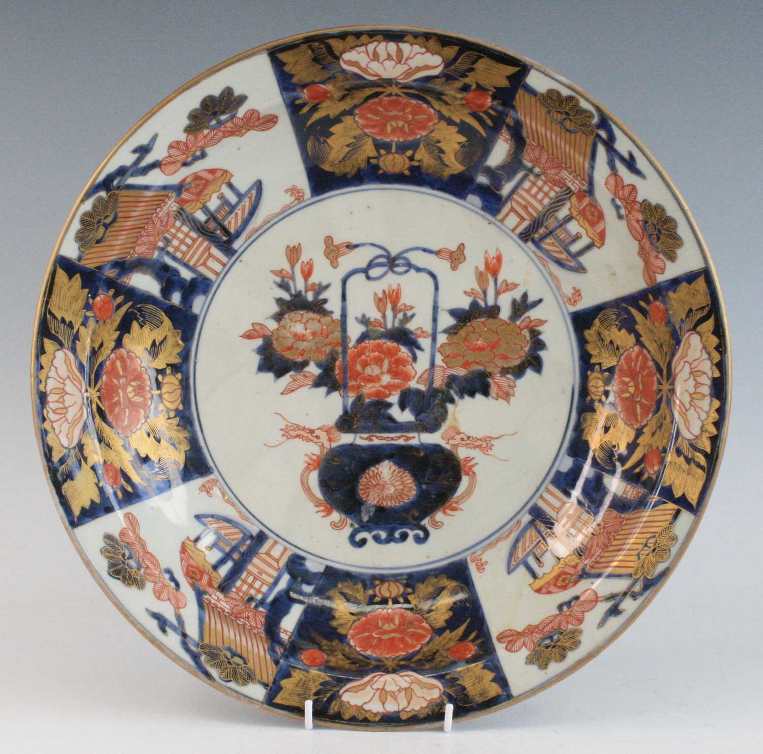 A Japanese Imari porcelain charger, 18th century, decorated with a basket of flowers within a border
