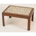 A 1970s G-Plan teak and tile top inset small coffee table, having rounded corners, with pinched