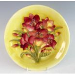 A mid-20th century Moorcroft African Lily pattern pottery charger, of typical circular shallow form,