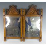 A pair of ecclesiastical Arts & Crafts oak framed wall mirrors, each having lancet shaped tops,