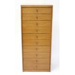 A 1960s teak narrow chest of ten long drawers, each with lacquered brass loop handle, h.142cm, w.