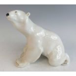 A mid-20th century Russian glazed ceramic model of a polar bear, in seated pose, printed factory