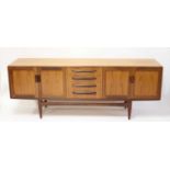 A 1960s G-Plan 'Fresco' teak long sideboard, having four central drawers flanked by twin panelled