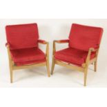 A pair of 1960s beech framed open armchairs, each having red fabric upholstered squab back and
