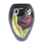 A mid-20th century Moorcroft pottery vase, decorated with a single rose head upon a blue background,