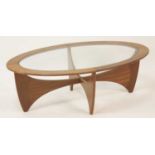 A 1960s G-Plan teak oval 'Astro' coffee table, having a glass inset top raised on curved X-frame