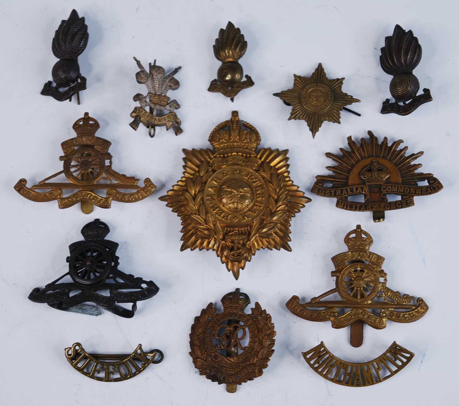 A small collection of metal insignia, to include a Royal Marines helmet plate, cap badges for the
