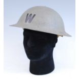 A WW II British Home Front Wardens steel helmet with stencilled W to the front, having a leather
