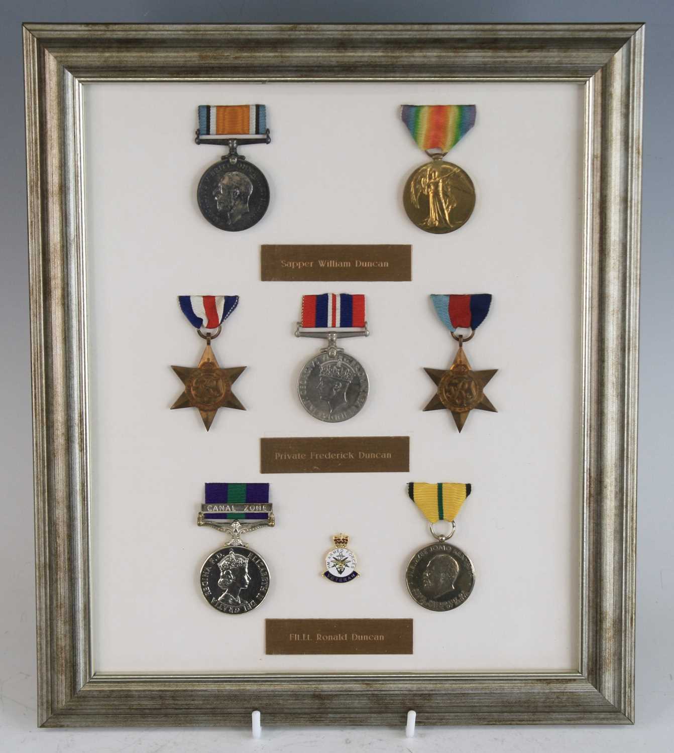 A family group of medals mounted for display with name plaque below, to include WWI British War