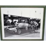 A signed photographic print of Stirling Moss in 1961 beside his SWB Ferrari 250GT, signed by Moss