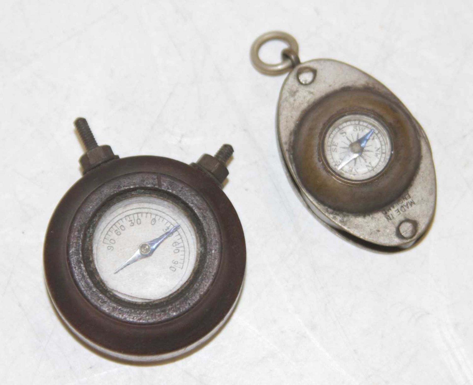 A miniature pocket compass, with inset loup, together with a miniature dashboard(?) compass (2)