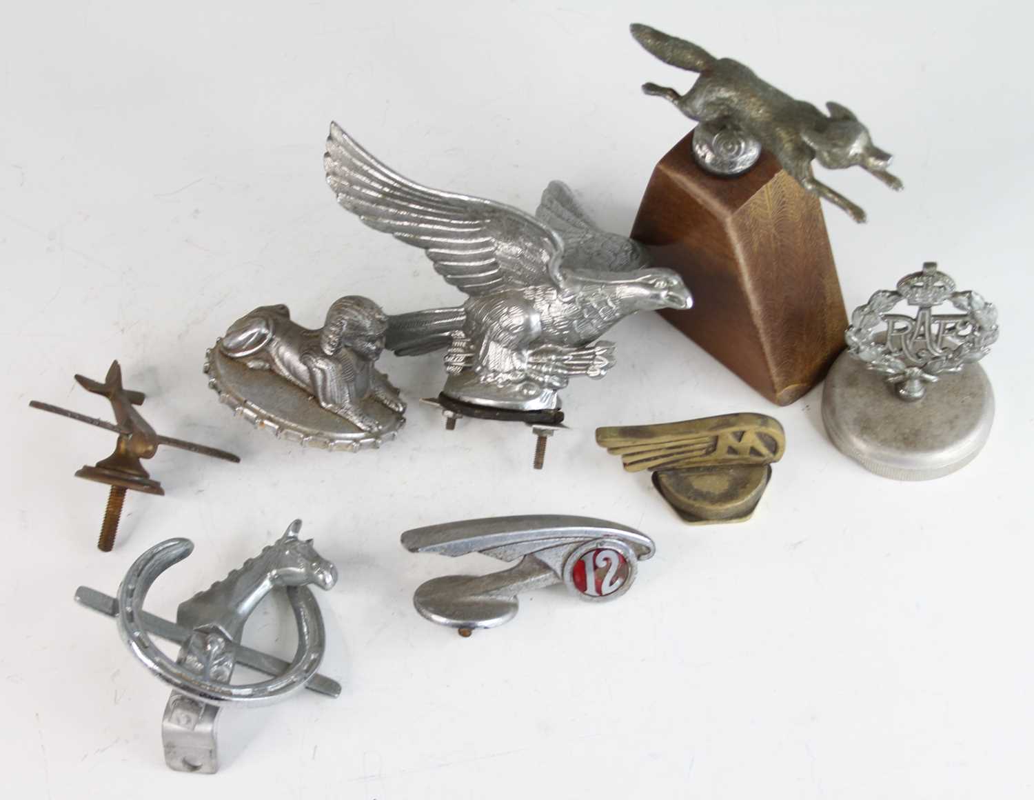 A collection of eight various vintage chromed metal and brass car mascots, to include a stylised