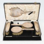 A George V silver backed dressing table brush set, with engine turned engraving, London 1928, cased