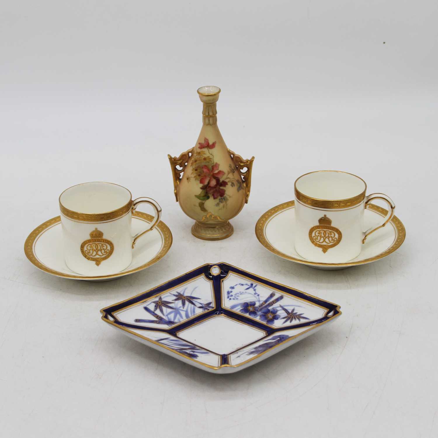 A pair of Royal Worcester coffee cans, each decorated with gilt borders, together with a Worcester