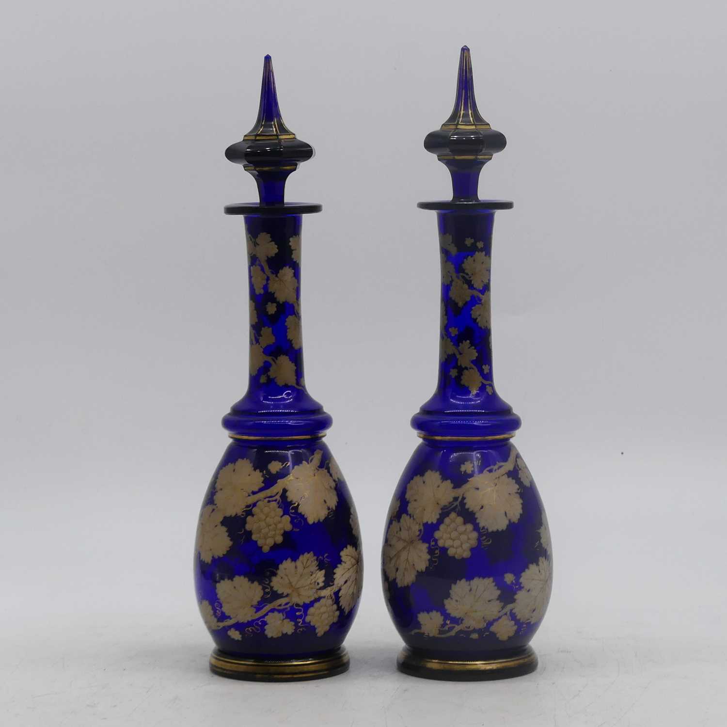 A pair of 19th century Bohemian style blue overlaid glass decanters, each decorated with trailing