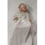 An early 20th century Armand Marseilles bisque head doll, having rolling brown eyes, open mouth with