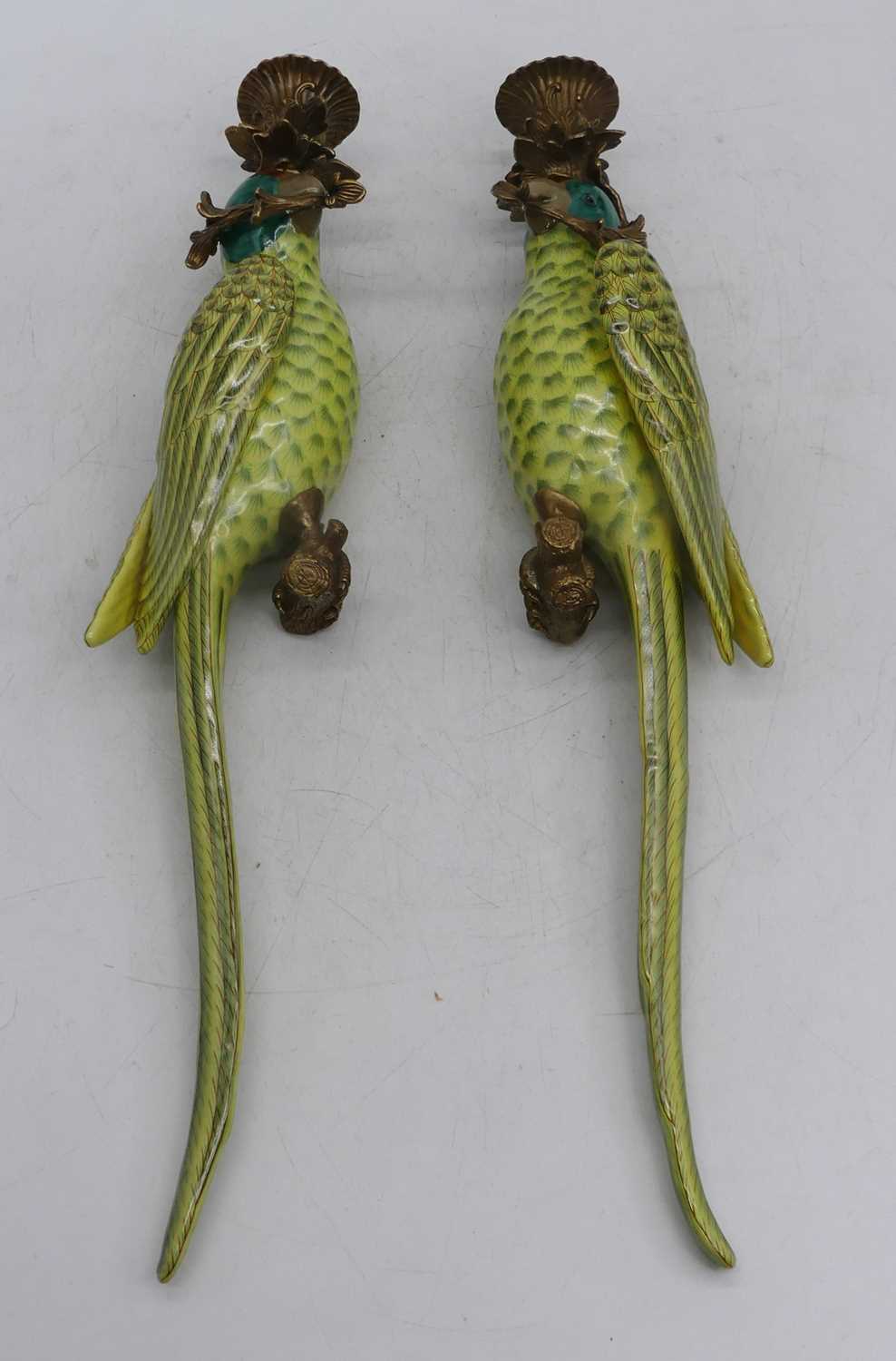 A pair of porcelain wall sconces, each in the form of a parrot, having gilt metal mounts, height