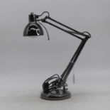 A modern angle poise desk lamp, all adjustable