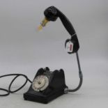 A black bakelite cased rotary dial telephone, converted into a desk lamp, height 40cm