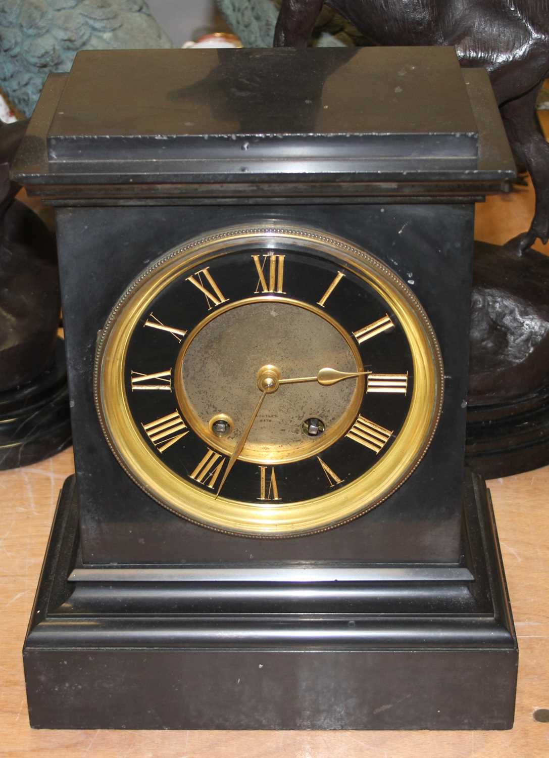 A 19th century black slate mantel clock, the chapter ring showing gilt Roman numerals, having 8-