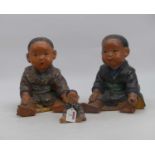 A pair of painted plaster figures of infants, each shown in seated pose, height 26cm, together