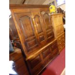 An antique joined oak housekeeper's cupboard, having twin recessed panelled upper cupboard doors