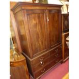 An early 19th century mahogany linen press, the twin panelled upper doors enclosing five linen