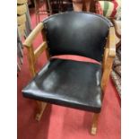 An Art Deco oak framed tub elbow chair, with black vinyl and brass studded pad back and seat Width