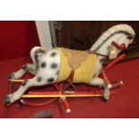 A mid-20th century child's moulded plastic and wrought metal framed rocking horse