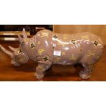 A composite painted model rhino with applied sticker motifs, length 52cm