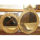 A gilt composition framed circular wall mirror, dia.49cm; together with an oval wall mirror (2)