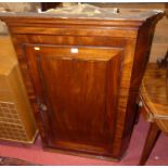 An early 19th century mahogany single door hanging corner cupboard, height 112cm