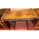 A Chinese "rosewood" altar table having rounded ends, raised floral and fruit detailed frieze to