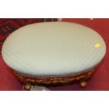 A gilt floral carved fabric upholstered oval foot stool in the French taste, width 48cm