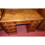 A circa 1900 mahogany and tan leather inset twin pedestal writing desk, having an arrangement of 9