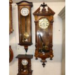 Two late 19th century walnut and ebonised Vienna drop trunk wall clocks, the larger with two weights
