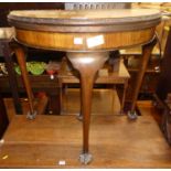 An early 20th century walnut and figured walnut demi lune fold over baize lined card table, having