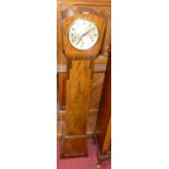An Art Deco figured walnut grandmother clock, the three winding holes with striking and chiming