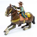A Haji Toys of Japan tinplate and clockwork model of a cowboy on horseback, comprising of brown