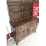 An Ercol dark elm dresser, w.130cmSome signs of wear to f drawers.Some marks to edges throughout and