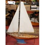 A wooden hull and weighted keel model yacht complete with nylet sails